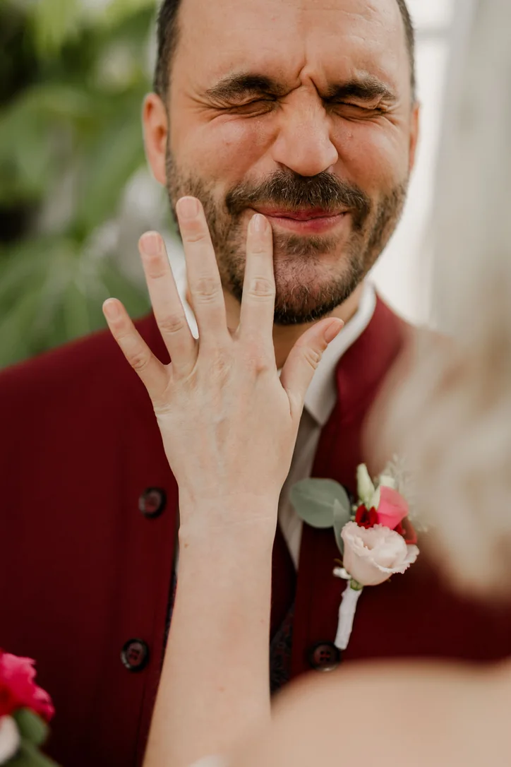 Bräutigam und Braut zeigen den Ehering nach ihrer Hochzeit im Schloss Wolfsberg