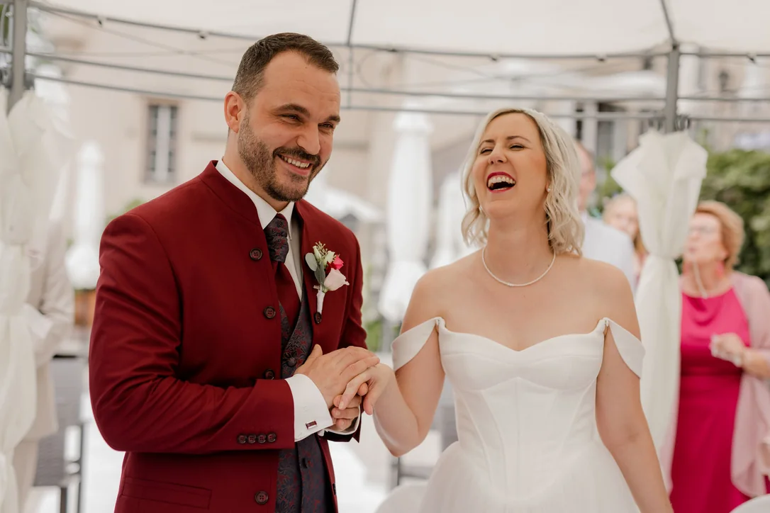 Brautpaar lacht während der persönlichen und familiären Hochzeit im Schloss in Kärnten